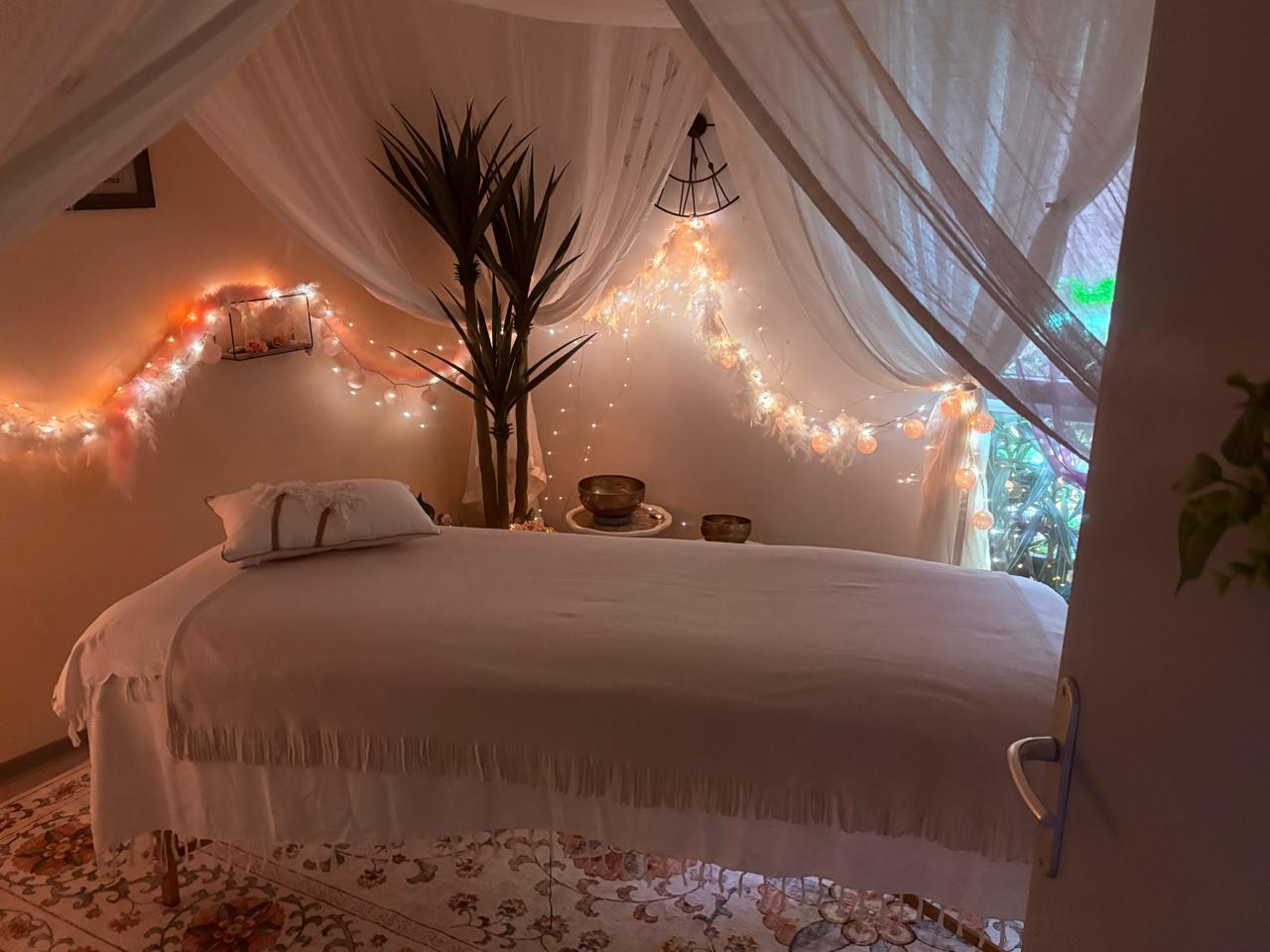 Cabinet de La Montagne — table de massage sous voilage et guirlandes lumineuses